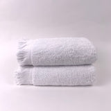 Two white towels stacked on a light gray background