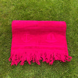 Pink towel with anchor and sailboat patterns on grass