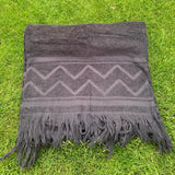 Gray towel with fringes on a grassy background