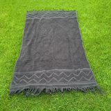 Gray towel with zigzag pattern on grass