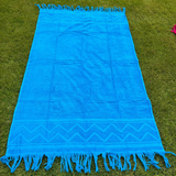 Blue towel with fringes on a grassy background