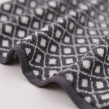 Close-up of textured fabric with geometric pattern on a light background