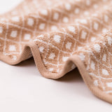 Close-up of a beige towel with white polka dot pattern on a light background