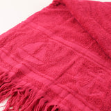 Close-up of a pink textured fabric with fringes on a white background