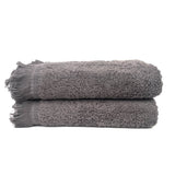 Two gray bath towels with fringes on a white background