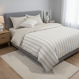 Neatly made bed with striped bedding in a bedroom setting.