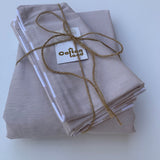 Folded beige fabric with twine and a tag on a white background
