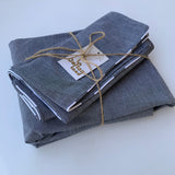 Set of gray fabric napkins tied with twine on a white background