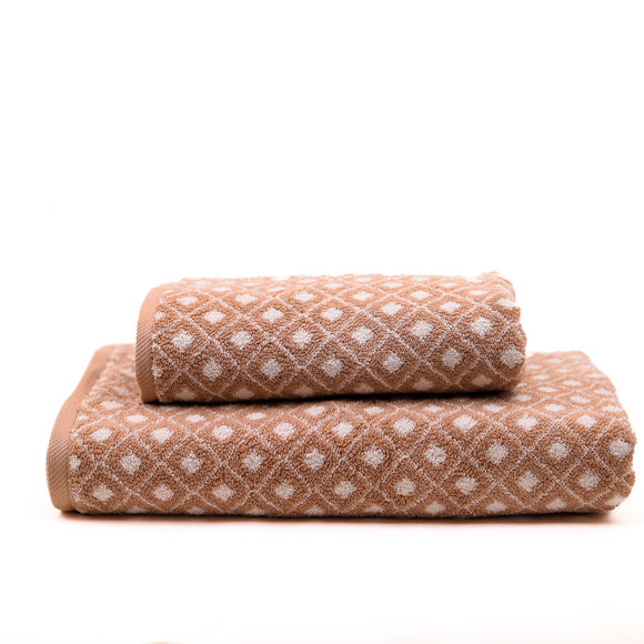 Two brown towels with white patterns stacked on a white background