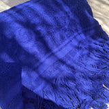 Blue towel with tassels on a textured surface