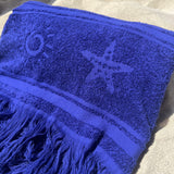 Blue towel with star design on a sandy surface