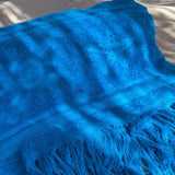 Blue towel with tassels on a textured surface
